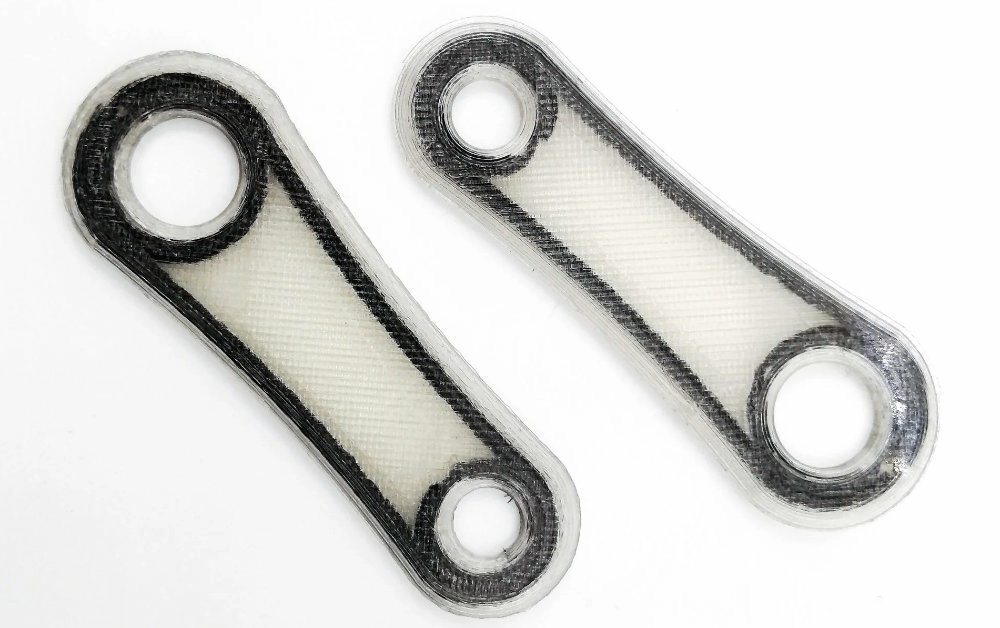 Армированная деталь непрерывным углеволокном в процессе печати Армированная деталь непрерывным углеволокном в процессе печати