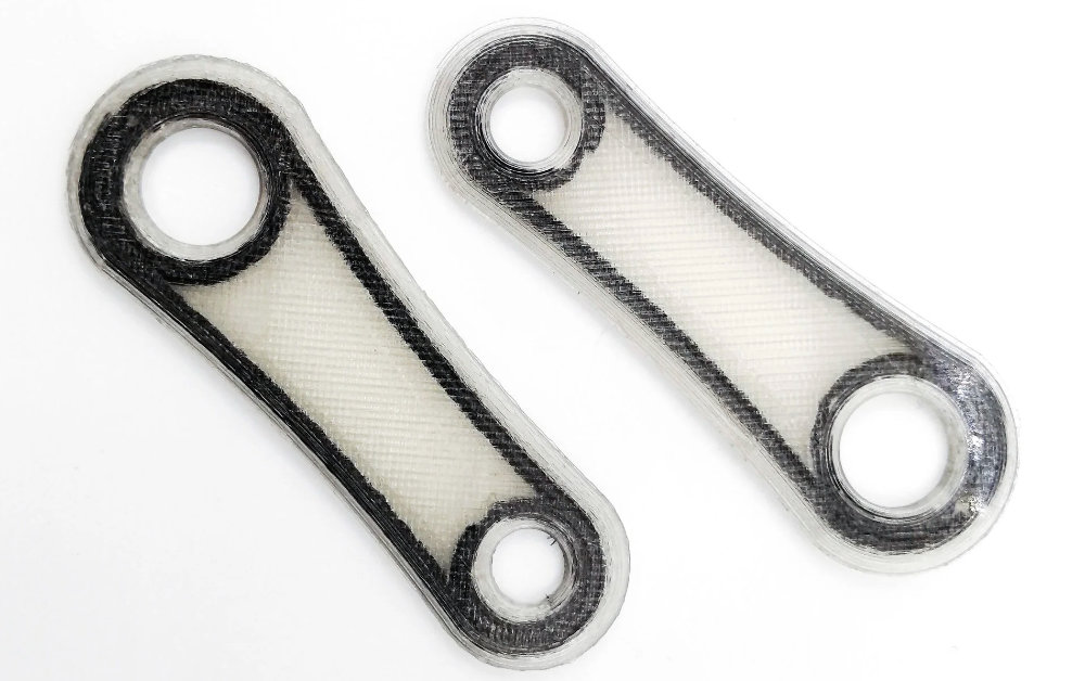 Армированная деталь непрерывным углеволокном в процессе печати Армированная деталь непрерывным углеволокном в процессе печати